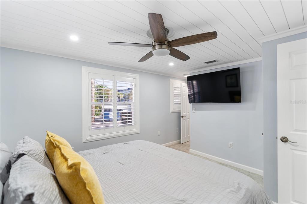 9022 Midnight Pass Road, Unit 112 Sarasota, FL 34242 - Photo 18 of 40 a bedroom with a bed and a flat screen tv