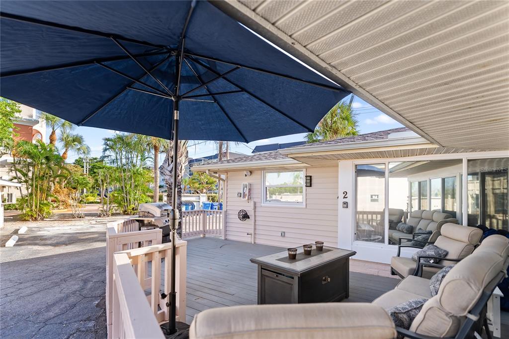 9022 Midnight Pass Road, Unit 112 Sarasota, FL 34242 - Photo 22 of 40 a outdoor space with patio the couches and pool table under an umbrella
