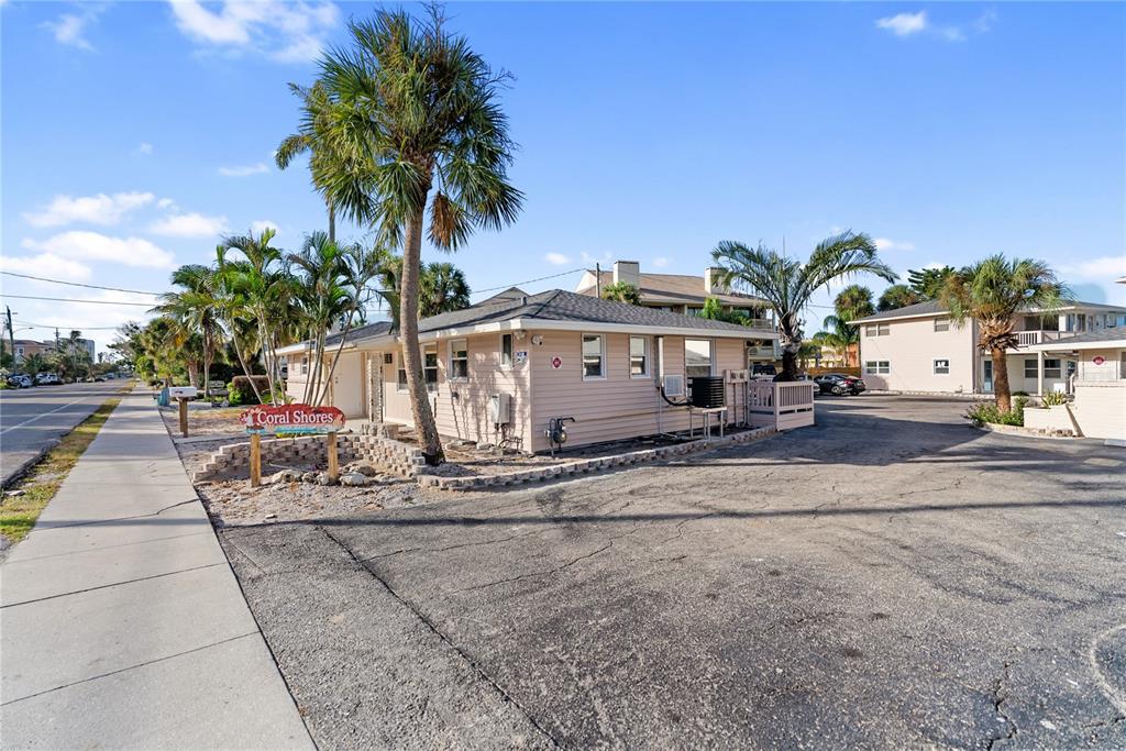 9022 Midnight Pass Road, Unit 112 Sarasota, FL 34242 - Photo 31 of 40 a front view of a house with a yard and garage