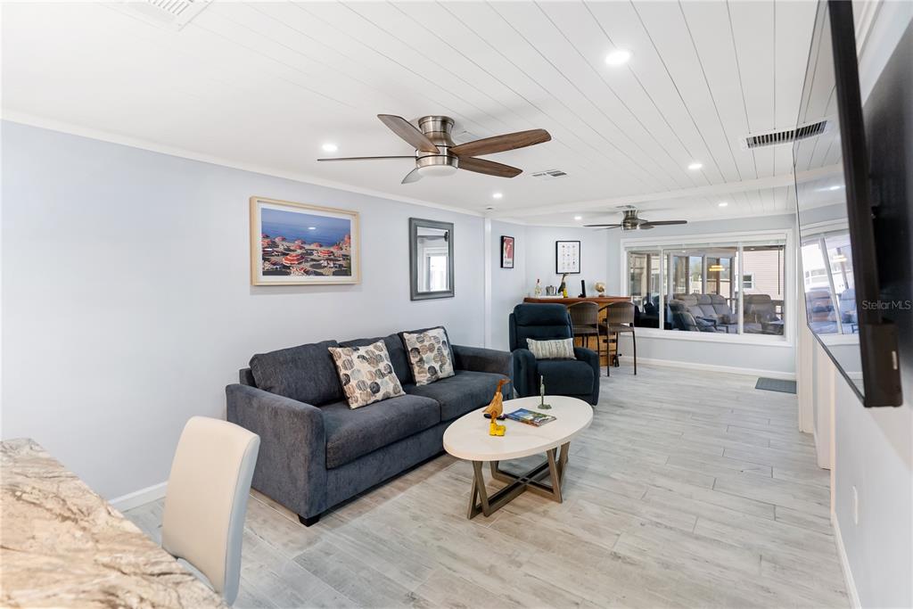 9022 Midnight Pass Road, Unit 112 Sarasota, FL 34242 - Photo 4 of 40 a living room with furniture a table and kitchen view