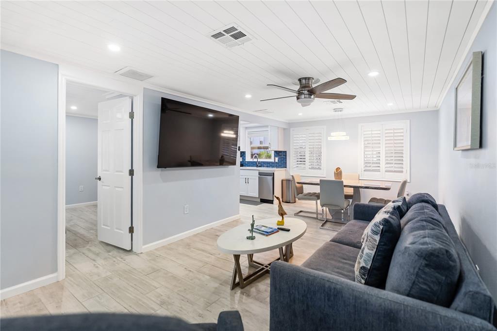 9022 Midnight Pass Road, Unit 112 Sarasota, FL 34242 - Photo 7 of 40 a living room with furniture and a flat screen tv