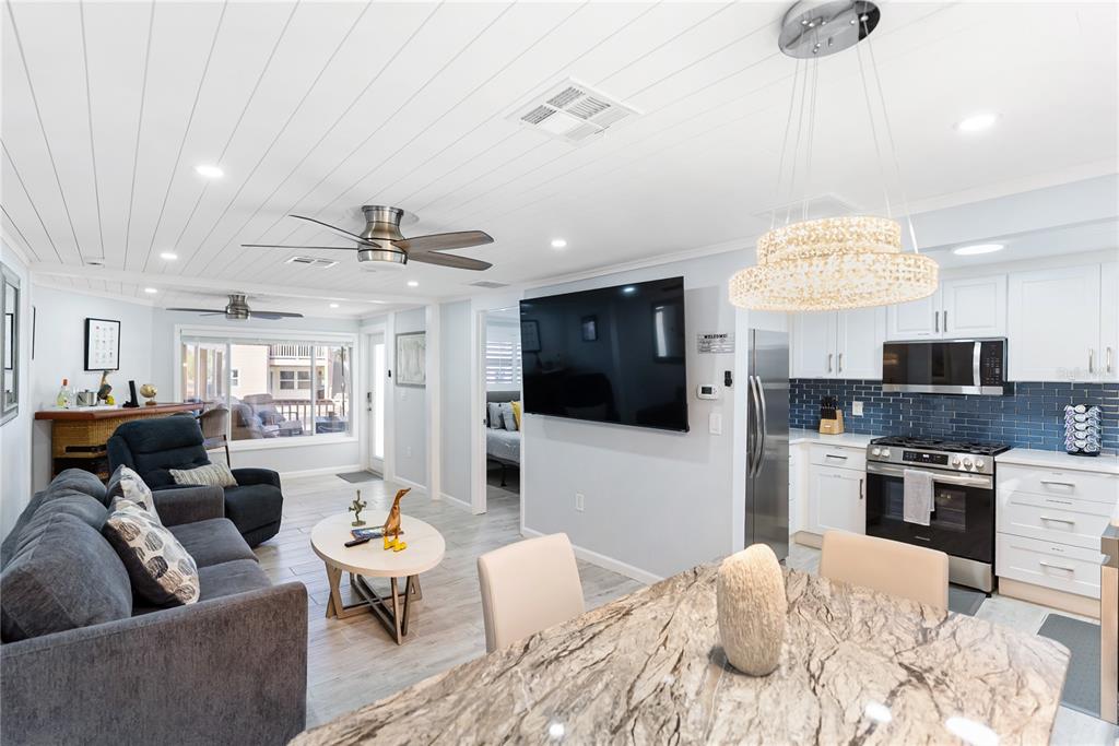 9022 Midnight Pass Road, Unit 112 Sarasota, FL 34242 - Photo 9 of 40 a living room with furniture kitchen and a chandelier