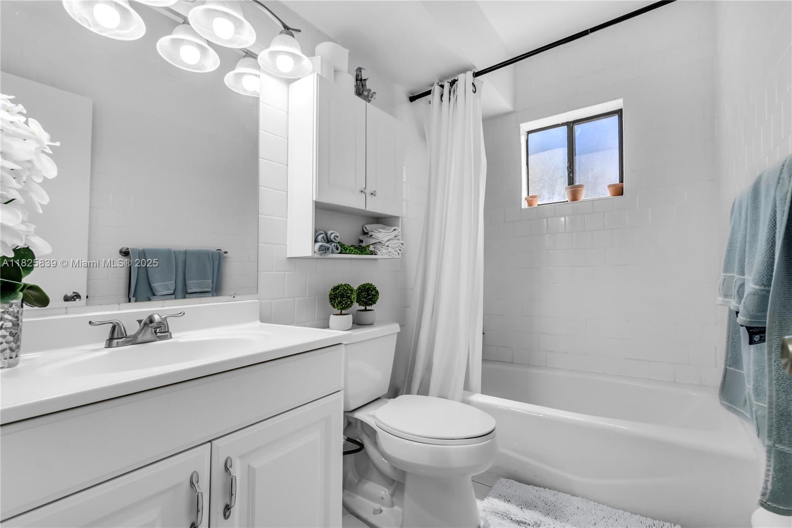 8400 Southwest 133rd Avenue Road, Unit 212 Miami, FL 33183 - Photo 16 of 32 a bathroom with a sink a toilet a mirror a bathtub and shower