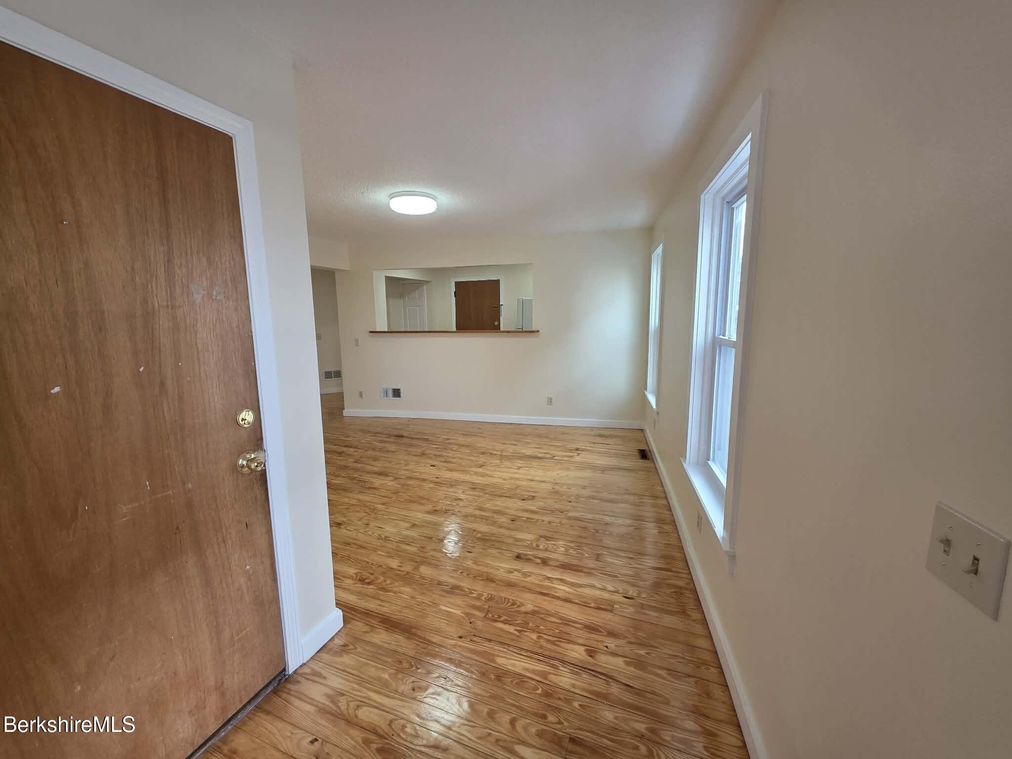 19 Pleasant Street, Unit 2B Adams, MA 01220 - Photo 6 of 14 a view of a hallway with wooden floor and a bathroom