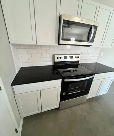 a kitchen with a stove and white cabinets