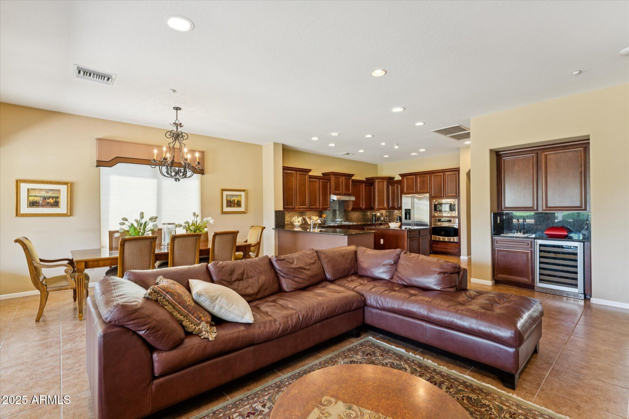 4959 North Village Road Litchfield Park, AZ 85340 - Photo 11 of 55 a living room with furniture kitchen view and a chandelier