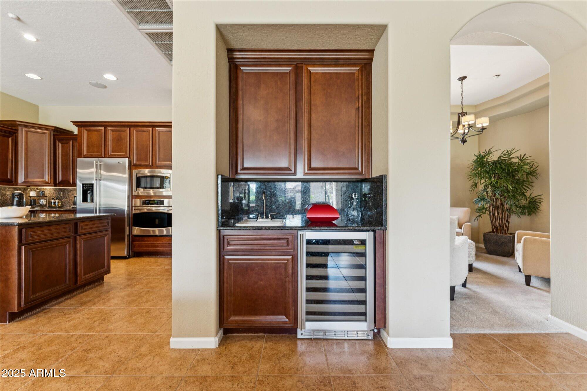 4959 North Village Road Litchfield Park, AZ 85340 - Photo 17 of 55 a kitchen with granite countertop a refrigerator and a stove top oven