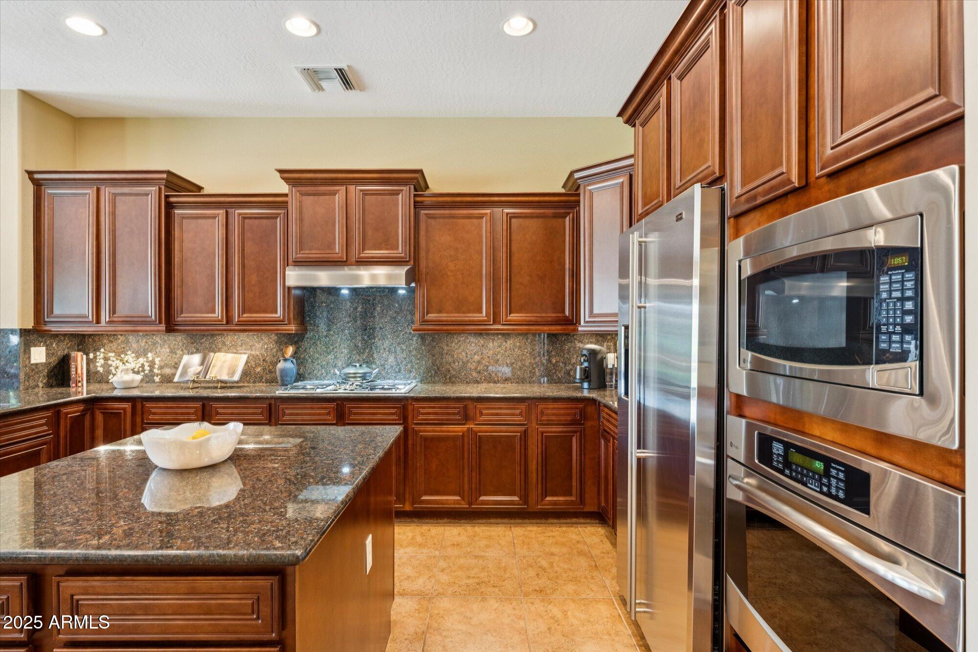 4959 North Village Road Litchfield Park, AZ 85340 - Photo 19 of 55 a kitchen with stainless steel appliances granite countertop a sink and a stove