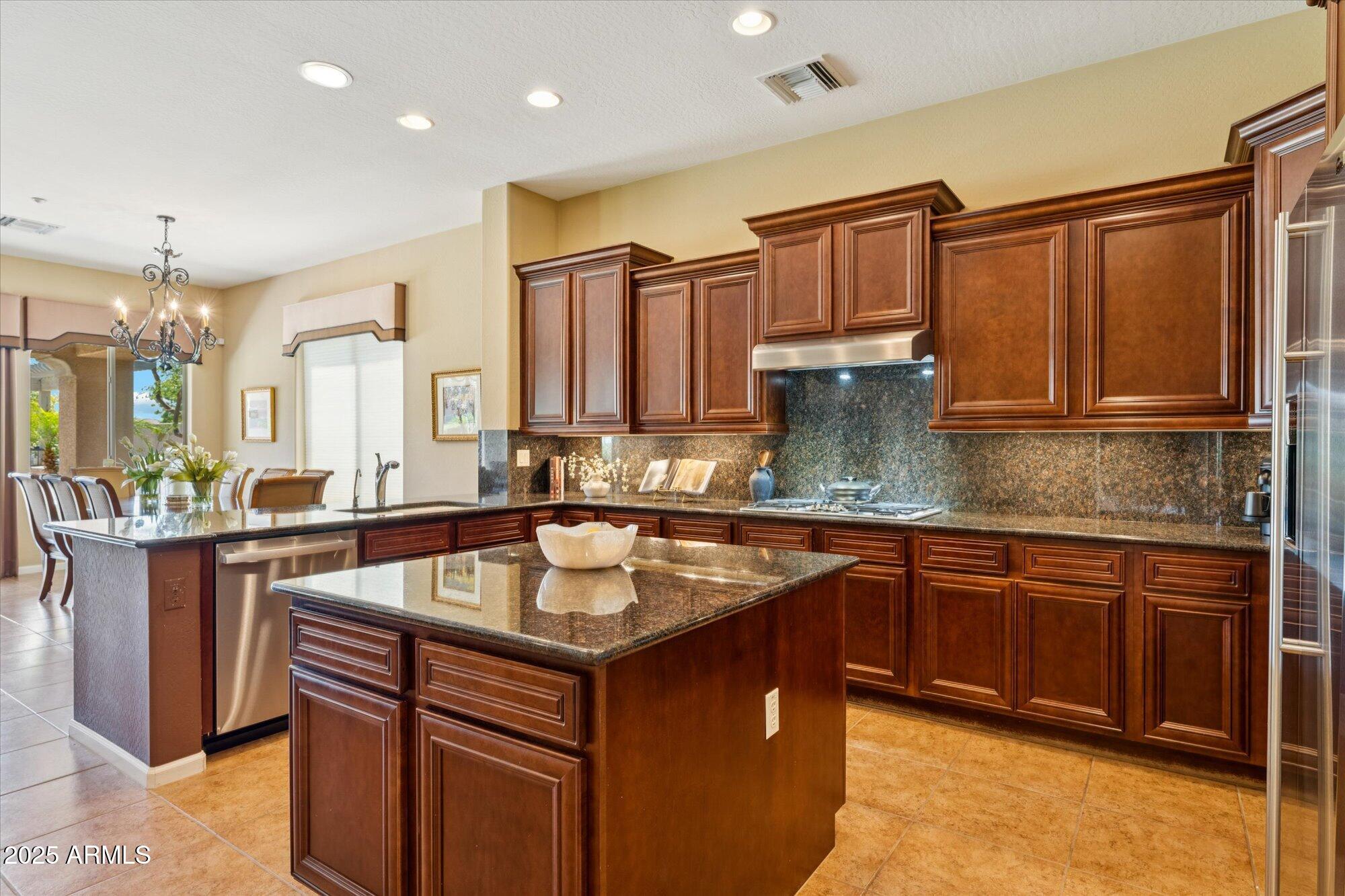 4959 North Village Road Litchfield Park, AZ 85340 - Photo 23 of 55 a kitchen with stainless steel appliances granite countertop a sink stove and cabinets