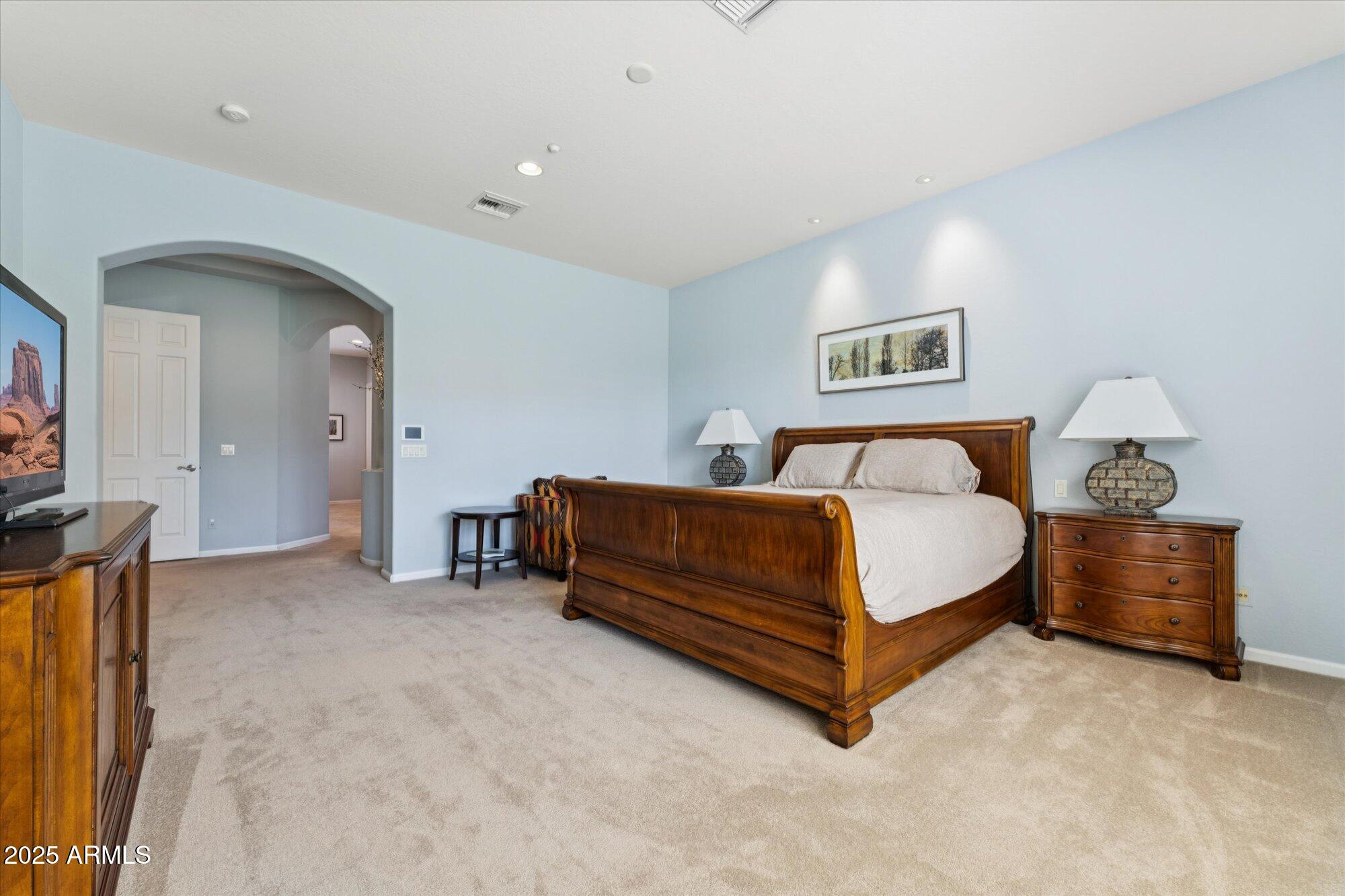 4959 North Village Road Litchfield Park, AZ 85340 - Photo 27 of 55 a bedroom with a bed and a chandelier