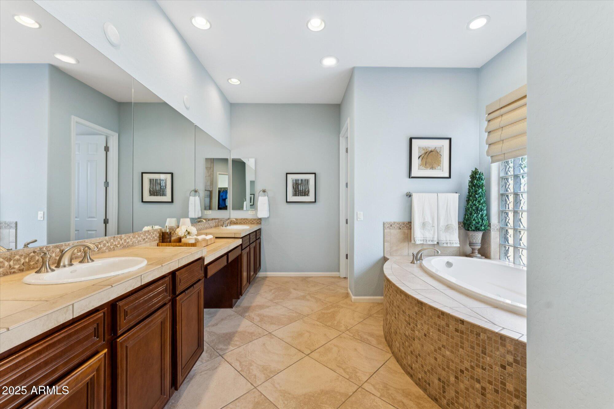 4959 North Village Road Litchfield Park, AZ 85340 - Photo 29 of 55 a large bathroom with a granite countertop double vanity sink a mirror and a bathtub
