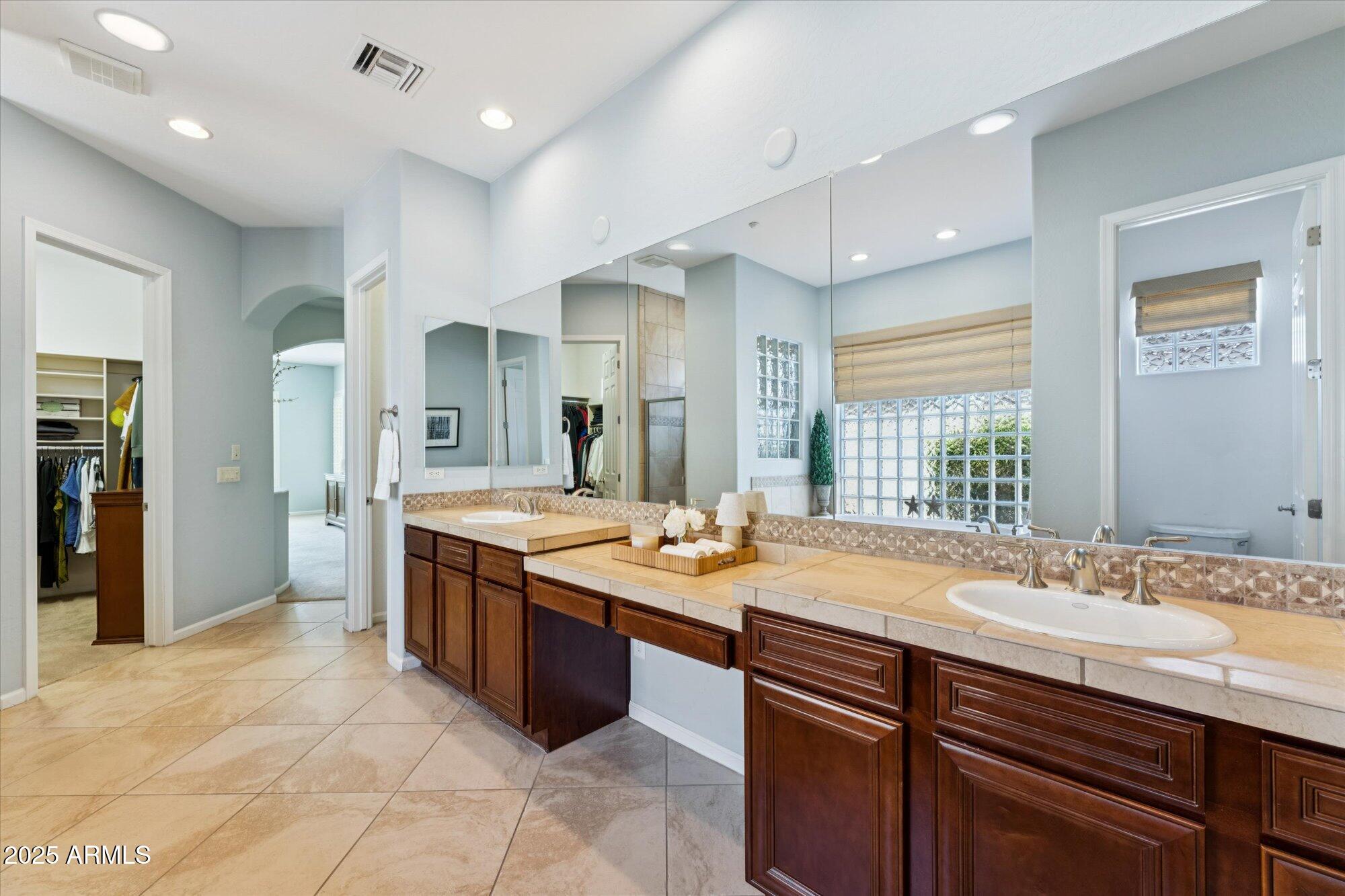 4959 North Village Road Litchfield Park, AZ 85340 - Photo 31 of 55 a bathroom with a granite countertop sink and a mirror