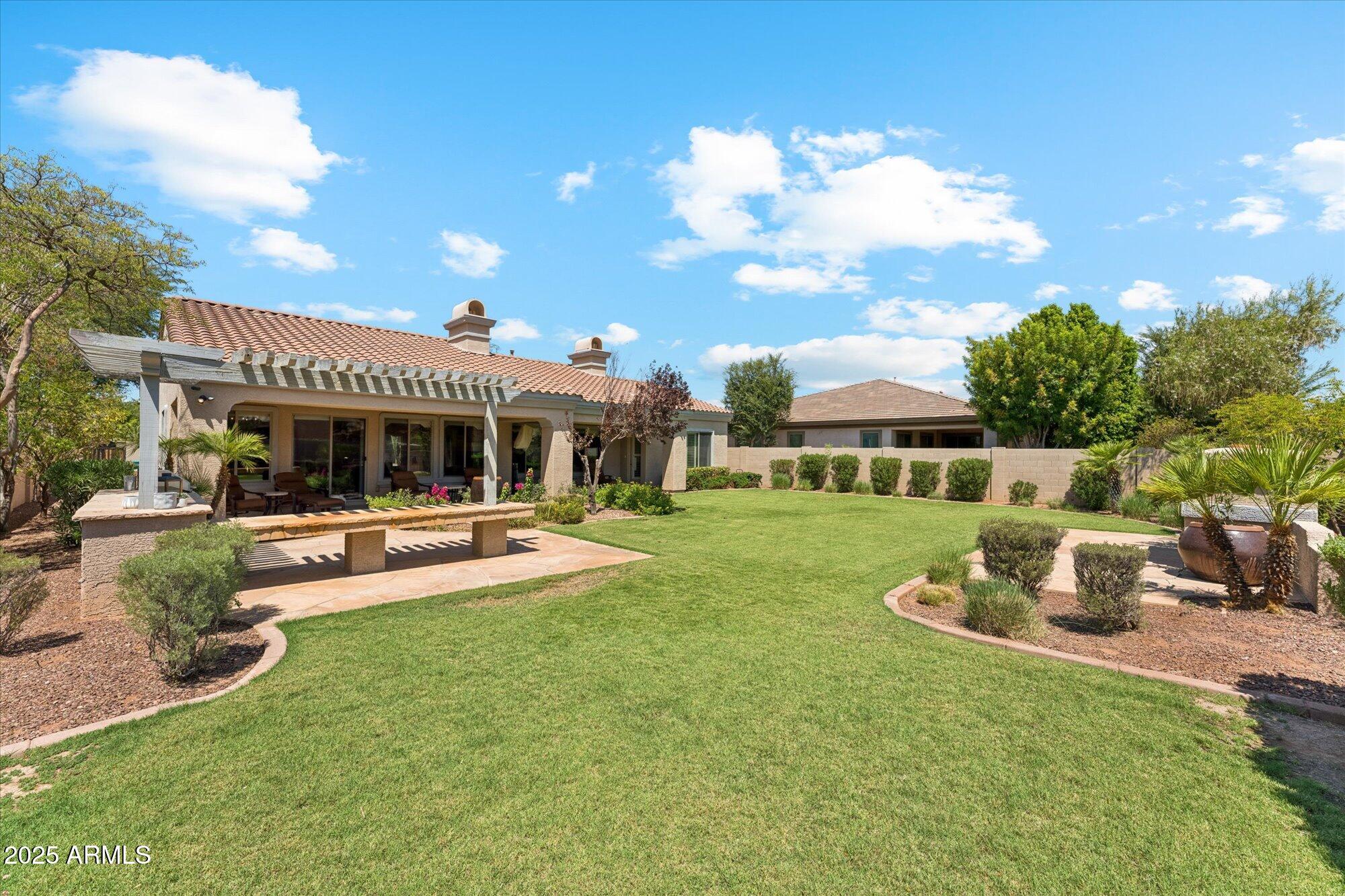 4959 North Village Road Litchfield Park, AZ 85340 - Photo 43 of 55 a view of a house with backyard sitting area and garden