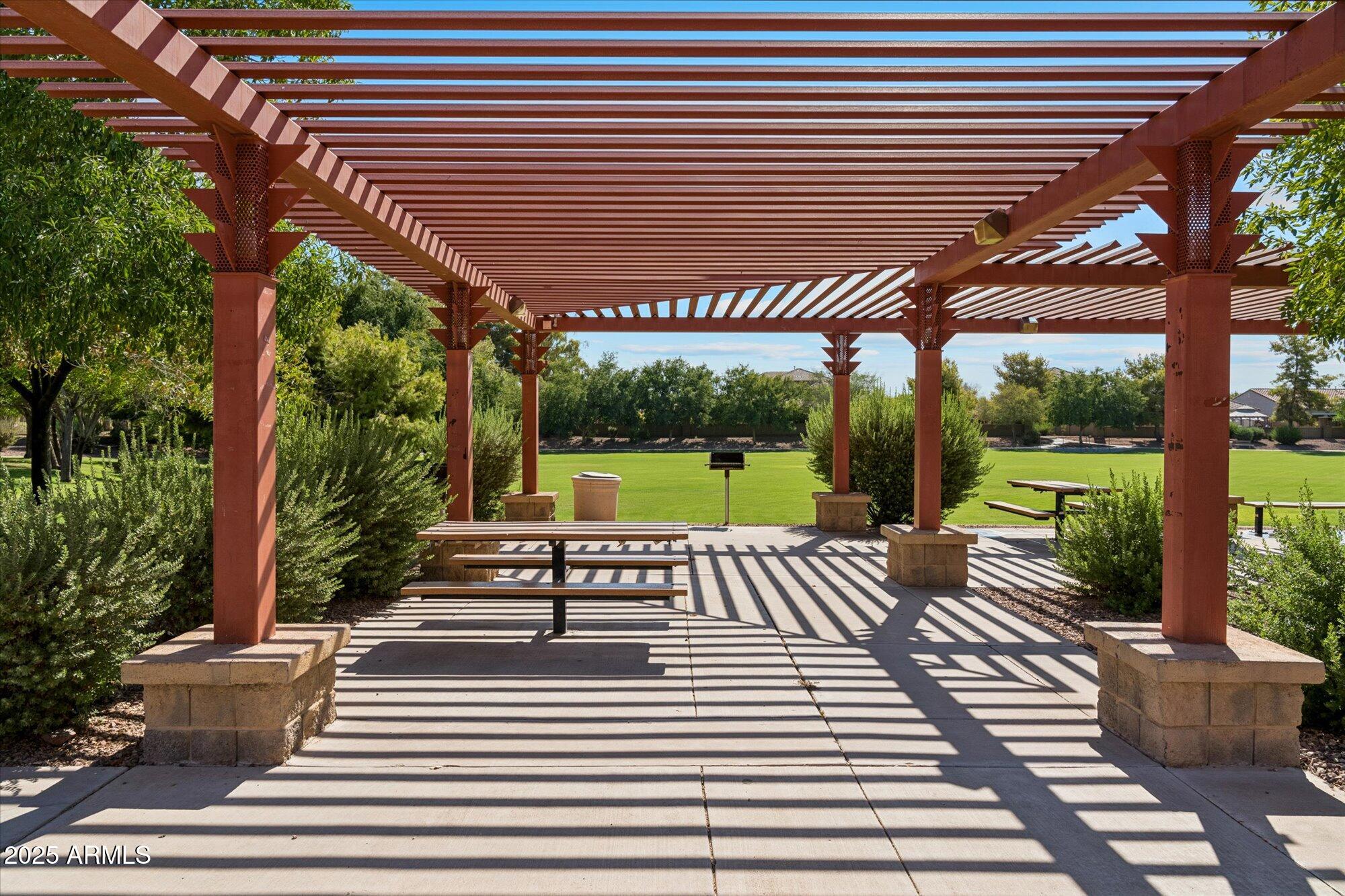 4959 North Village Road Litchfield Park, AZ 85340 - Photo 50 of 55 a view of a patio with a table and chairs next to a yard