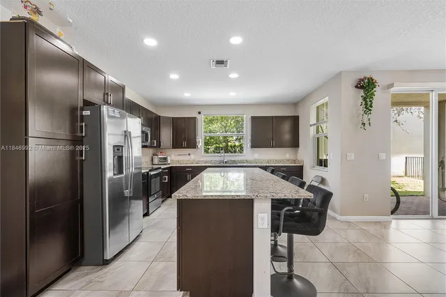 a kitchen with granite countertop a refrigerator and a sink
