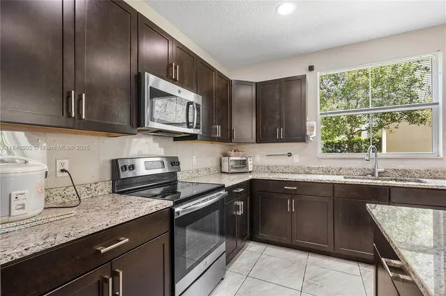 a kitchen with a sink stove top oven and cabinets