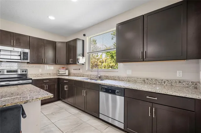 a kitchen with stainless steel appliances granite countertop wooden cabinets a sink and dishwasher