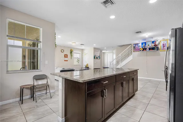 a kitchen with granite countertop a sink and a refrigerator