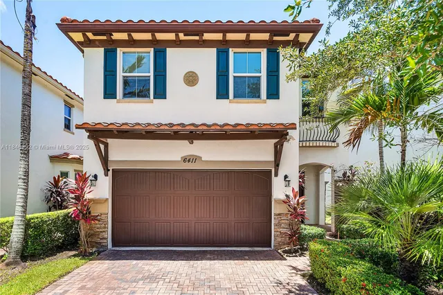 a front view of a house with plants