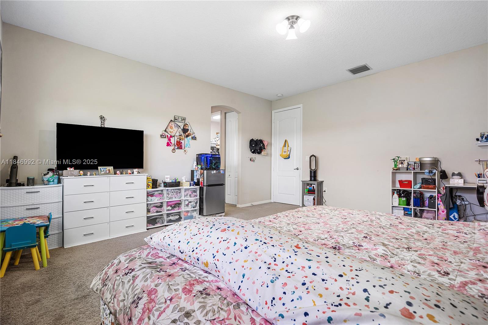 6411 Osprey Landing Street Davie, FL 33314 - Photo 24 of 38 a bedroom with a bed and a flat screen tv