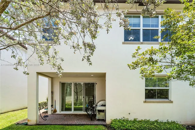 a view of a house with backyard and a tree