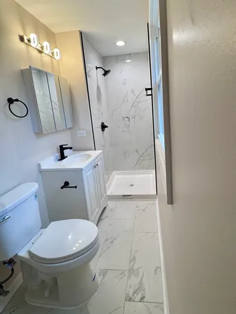 a white toilet sitting next to a bathroom sink
