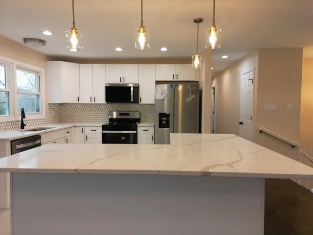 a large kitchen with a lot of cabinets and wooden floor