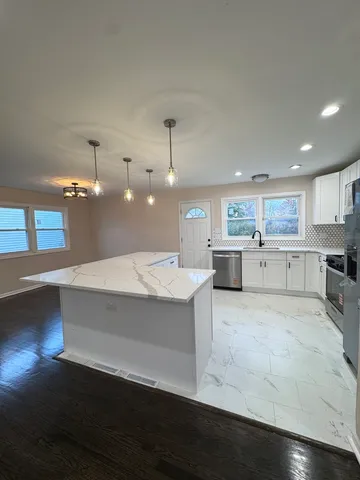 a large kitchen with stainless steel appliances a large counter top