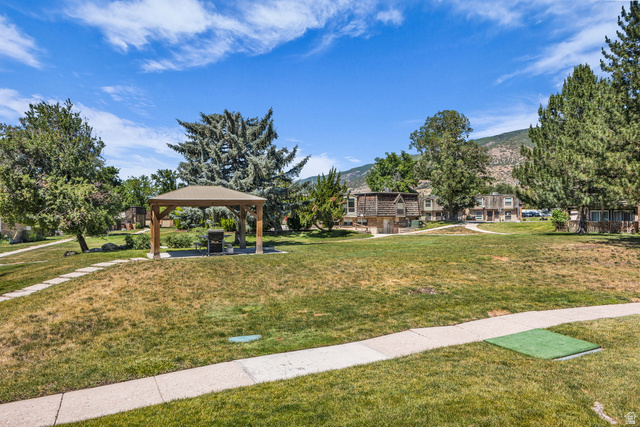 88 West 50 South, Unit C8 Centerville, UT 84014 - Photo 24 of 29 Expansive green space featuring a central gazebo with a built-in grill, mature trees, and concrete pathways