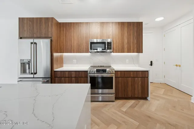 a kitchen with stainless steel appliances granite countertop a stove a sink and a refrigerator