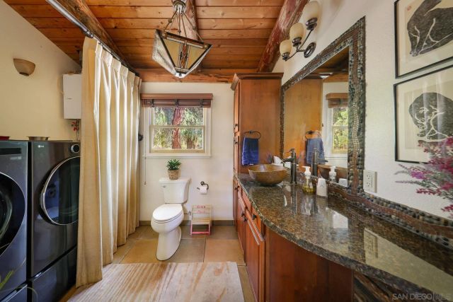 a bathroom with a granite countertop sink a toilet and a shower
