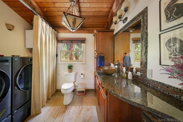 a bathroom with a granite countertop sink a toilet and a shower