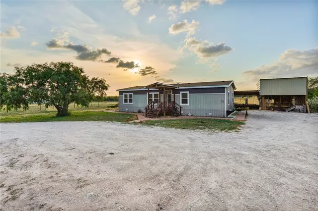 a view of a house with a yard and sitting area