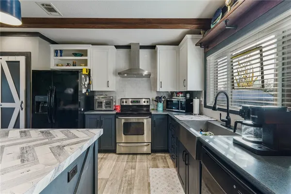 a kitchen with stainless steel appliances granite countertop a sink a stove and a refrigerator
