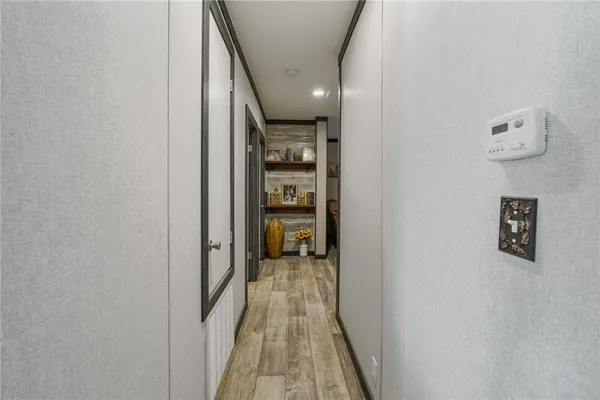 a view of a hallway with wooden shelves