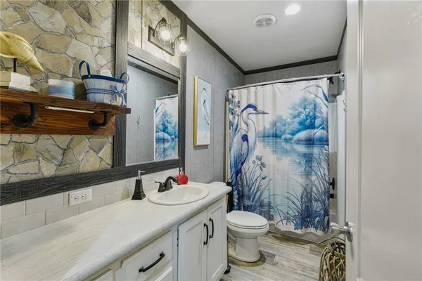 a bathroom with a sink toilet and shower