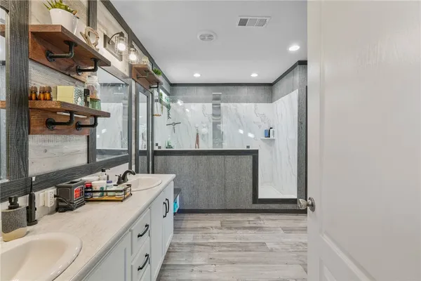a bathroom with a double vanity sink a mirror and shower