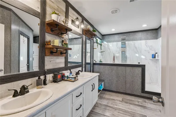a bathroom with double vanity and a mirror