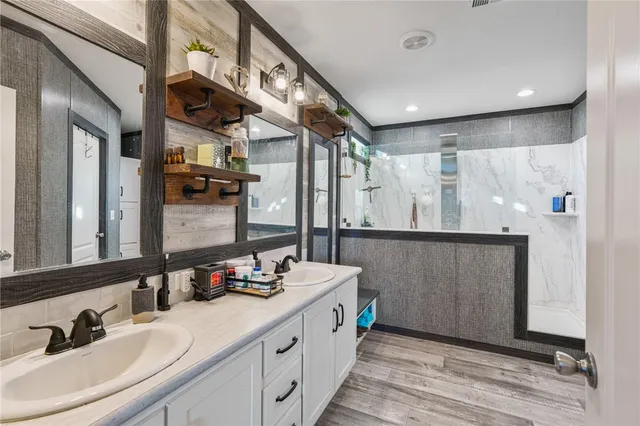 a bathroom with double vanity and a mirror
