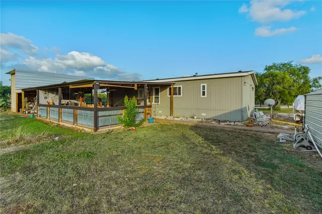 a backyard of a house with table and chairs