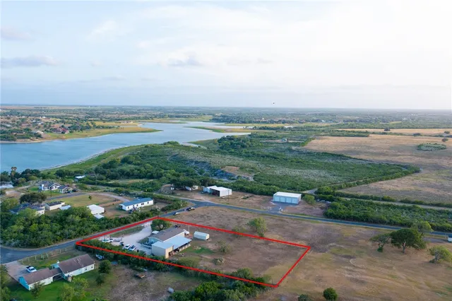 an aerial view of residential houses with outdoor space and river