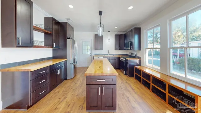 a kitchen with stainless steel appliances granite countertop a stove a sink and a refrigerator