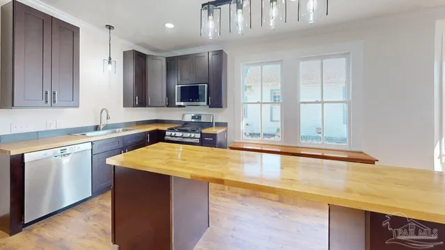 a kitchen with stainless steel appliances granite countertop a sink stove and cabinets