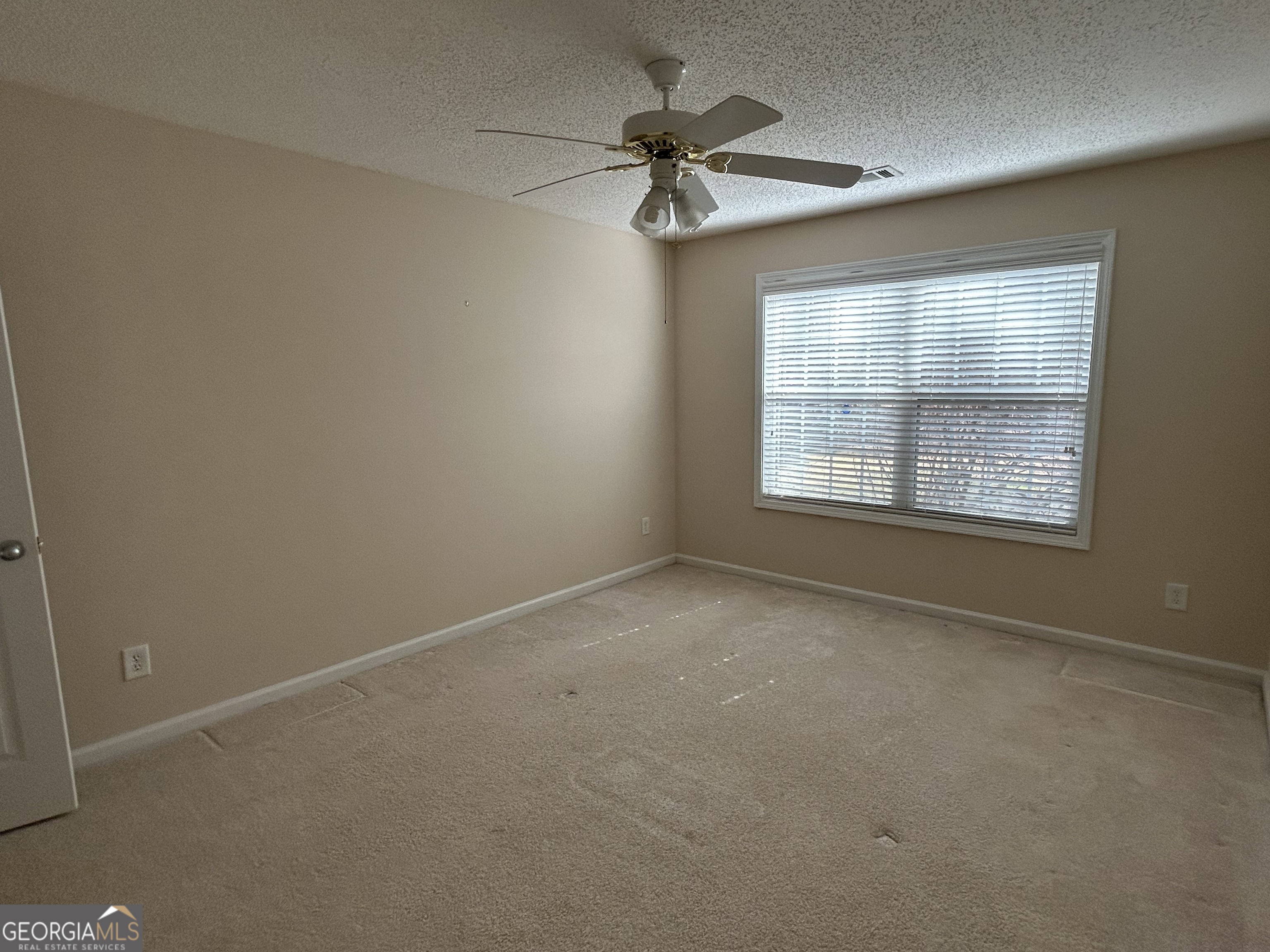 28 Pinewood Circle Colbert, GA 30628 - Photo 34 of 44 an empty room with a window and a fan