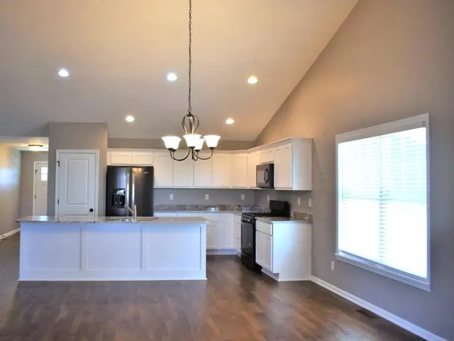 a view of a kitchen with a stove cabinets and a wooden floor