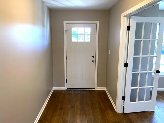 an empty room with wooden floor and a window
