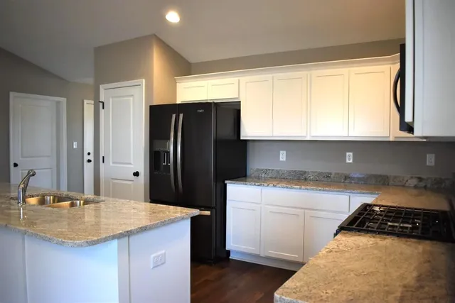 a view of a kitchen with granite countertop cabinets a dining table and chairs