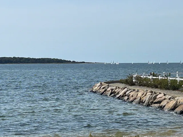 a white wall with painting on the wall and a white refrigerator