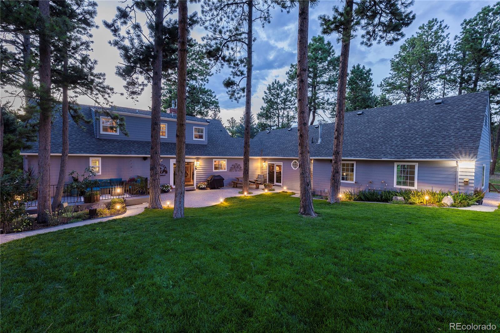 18975 Shadowood Drive Monument, CO 80132 - Photo 1 of 48 a view of a yard with a table and chairs under an umbrella