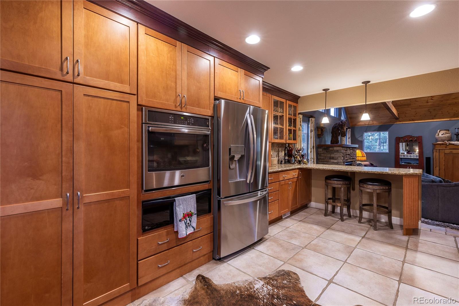 18975 Shadowood Drive Monument, CO 80132 - Photo 11 of 48 a kitchen with stainless steel appliances granite countertop a refrigerator and a stove top oven